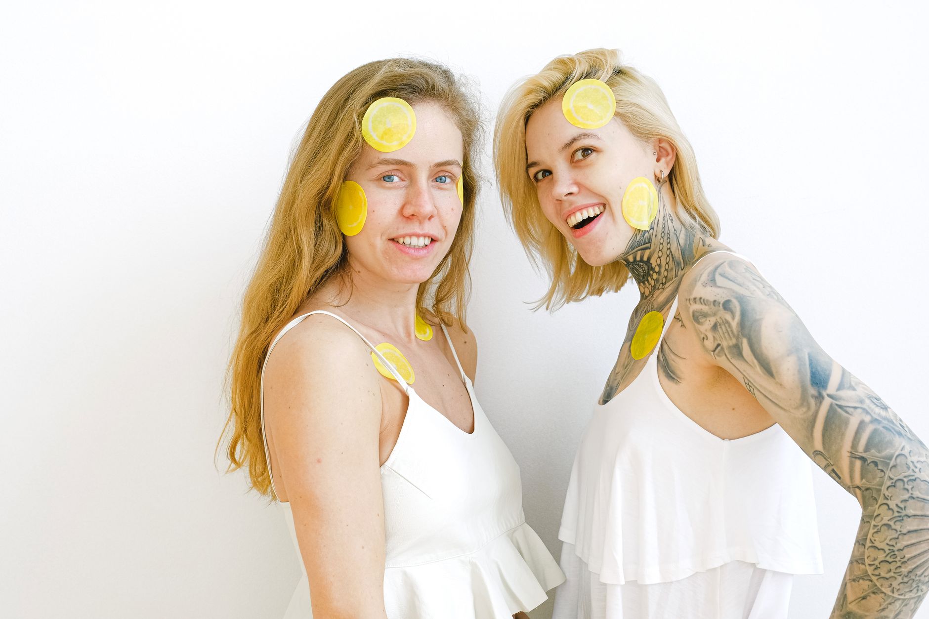 Hand holding a lemon on a soft pink background, symbolizing gentle sensuality during recovery