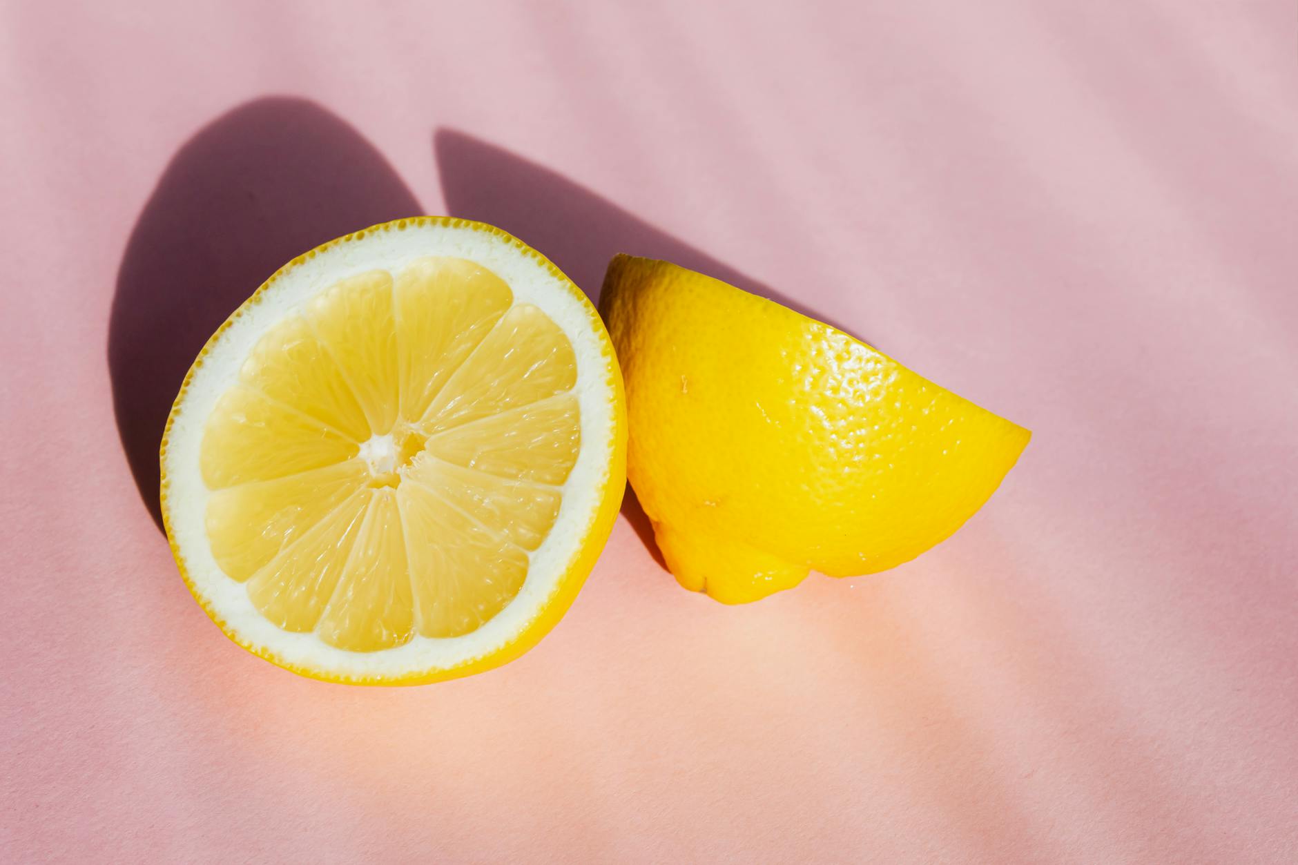 Bright fresh lemon halves on a pink background, symbolizing the slow buildup of sensation