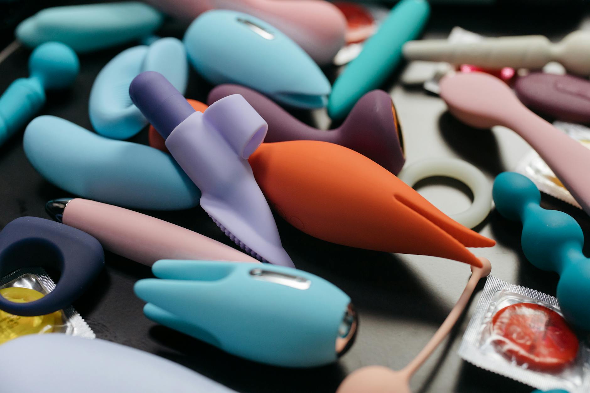 A young couple standing together indoors, holding a blue vibrator, symbolizing modern intimacy and connection.