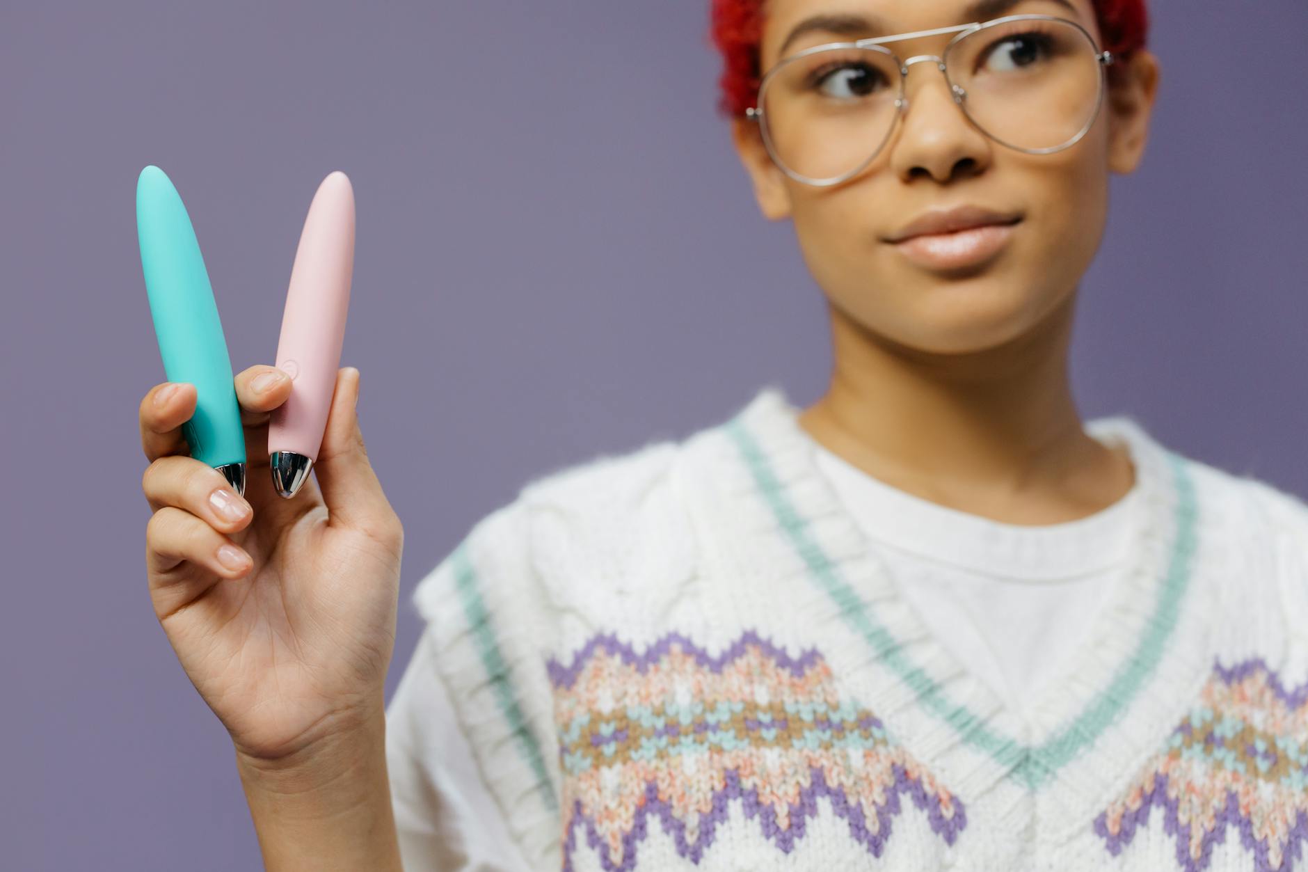 A woman holding colorful vibrators in a personal, intimate moment during her recovery journey