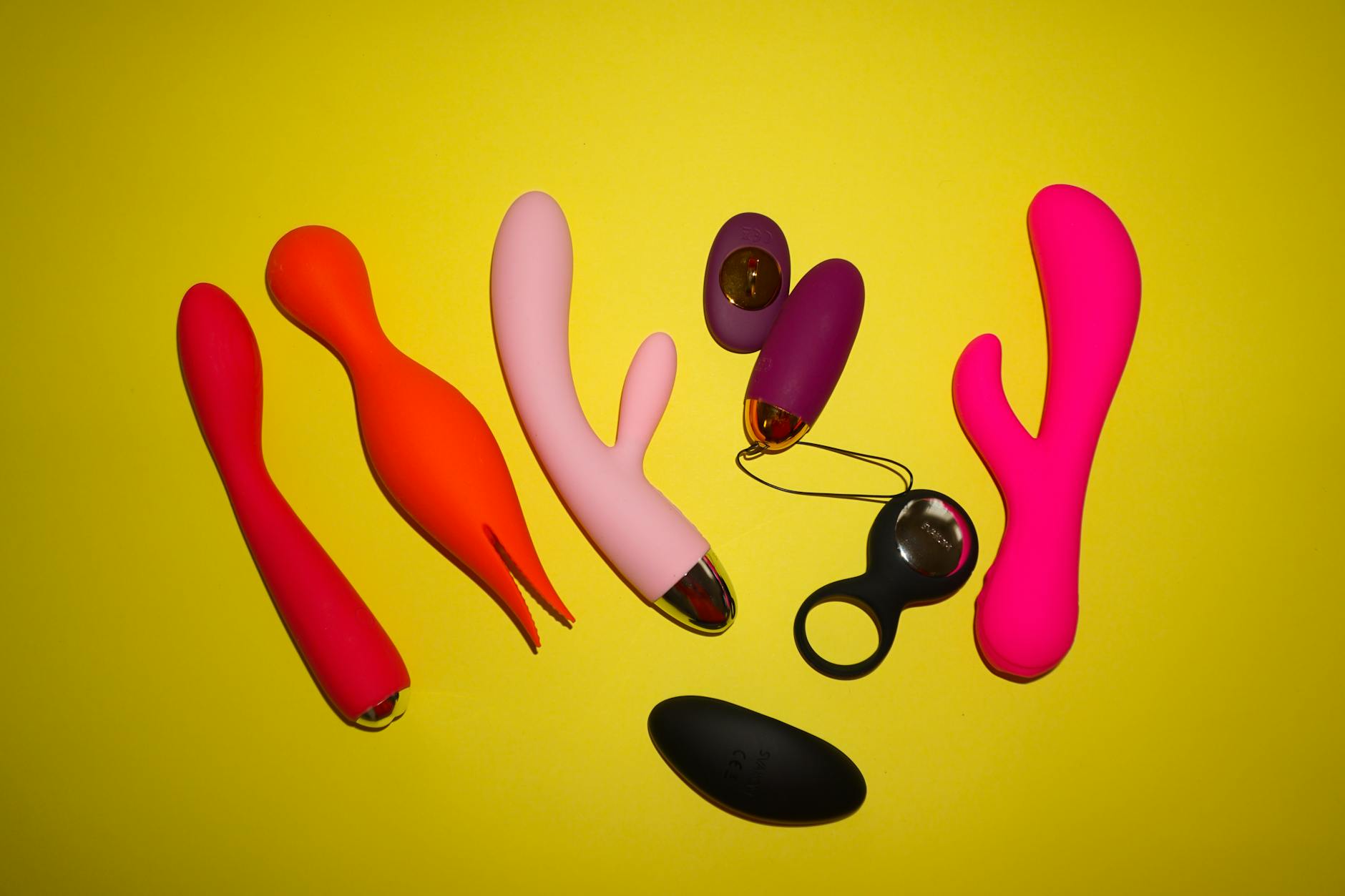 Hands holding a blue silicone vibrator against purple background